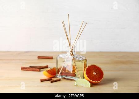 Reed diffuser with grapefruit and cinnamon on wooden table Stock Photo