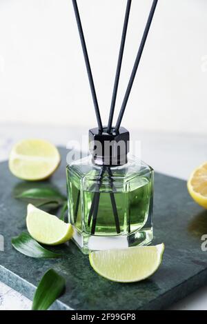 Reed diffuser with lemon and lime on light background Stock Photo