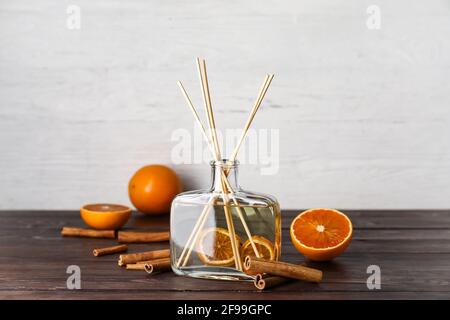 Citrus reed diffuser with cinnamon on wooden table Stock Photo
