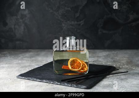 Reed diffuser with orange and cinnamon on grunge background Stock Photo