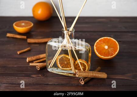 Citrus reed diffuser with cinnamon on wooden table Stock Photo