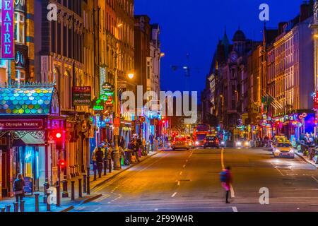 DUBLIN, IRELAND, MAY 9, 2017:  night view of people strolling through a busy street in the central Dublin, Ireland Stock Photo