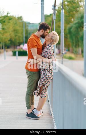 Couple hugging and kissing on bridge Stock Photo - Alamy