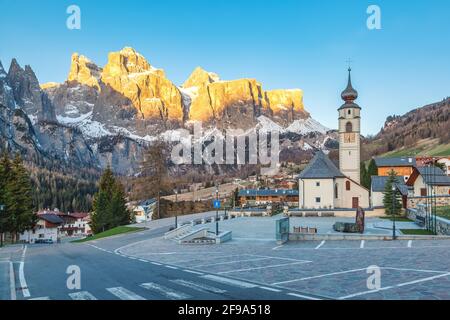 Colfosco, Alta Badia, Dolomites, South Tyrol, Italy. The village and the church of San Vigilio with the Sella group in background Stock Photo