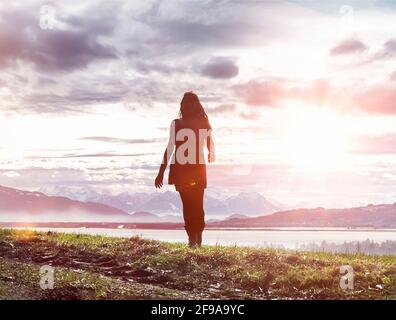 Young woman with long hair in front of Lake Constance panorama in the backlight Stock Photo