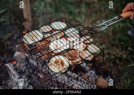 Assorted delicious grilled vegetables on barbecue grill with smoke and flames Stock Photo