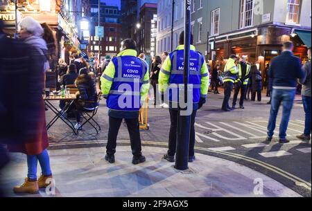 London, United Kingdom. 16th April 2021. Covid marshals on patrol in Old Compton Street, Soho. Crowds of people packed the bars and restaurants in Central London on the first Friday since lockdown rules were relaxed. Stock Photo