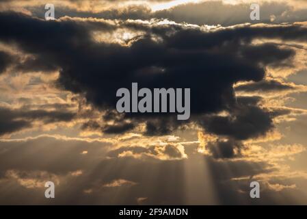 Evening sun behind dark clouds Stock Photo