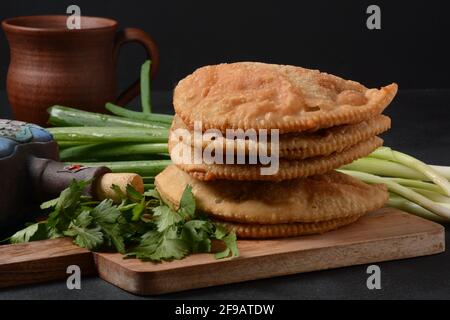 Chebureki - fried pies with meat and onions. Caucasian cuisine - is a patty made from thin unleavened dough with stuffed lamb and spicy seasonings. Stock Photo