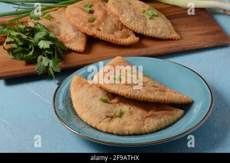 Chebureki - fried pies with meat and onions. Caucasian cuisine - is a patty made from thin unleavened dough with stuffed lamb and spicy seasonings. Stock Photo