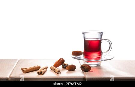 Turkish traditional tea with cinnamon sticks and dates, isolated on white background Stock Photo