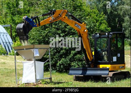 Bobcat loading sand into a radioactive waste storage container. October 1, 2018. State corporation Radon . Kiev, Ukraine Stock Photo