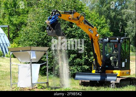 Bobcat loading sand into a radioactive waste storage container. October 1, 2018. State corporation Radon . Kiev, Ukraine Stock Photo