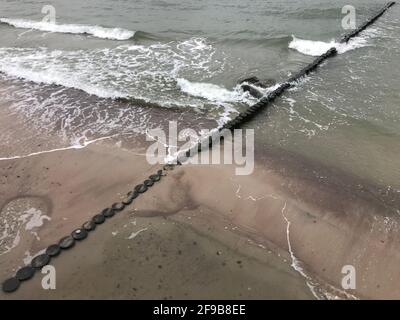 Breaking waves on a wooden breakwater on the Baltic Sea coast. Stock Photo