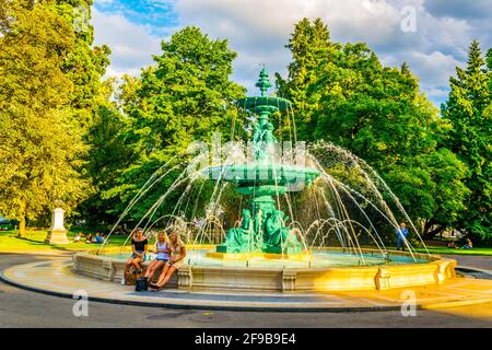 GENEVA, SWITZERLAND, JULY 20, 2017: People are sitting on a fountain in the Jardin Anglais park in Geneva, Swizerland Stock Photo