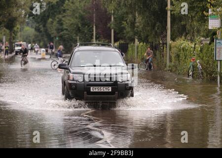A car driving through flood waters, Abingdon Road, west Oxford after unseasonal heavy rain led to river Thames and its tributaries breaking their banks. 250 homes in the Abingdon and Botley Road area of west Oxford where evacuated. Abingdon Road, Oxford, UK.  23 Jul 2007 Stock Photo