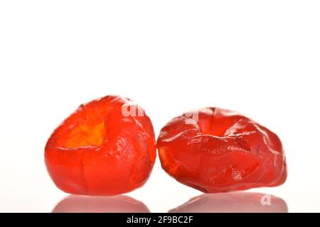 Two bright red organic, sweet and sour, dried cherries, close-up, on a white background. Stock Photo