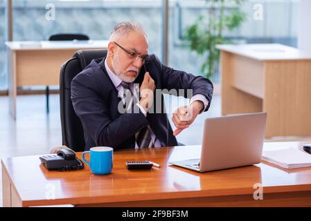 Senior businessman employee working in the office Stock Photo