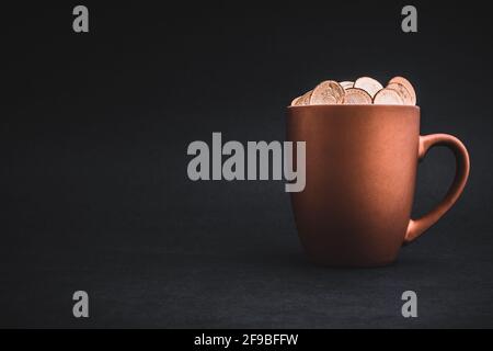 Golden Coins in cups on black background. Tax, Finance, Profit and Investment Concept Stock Photo