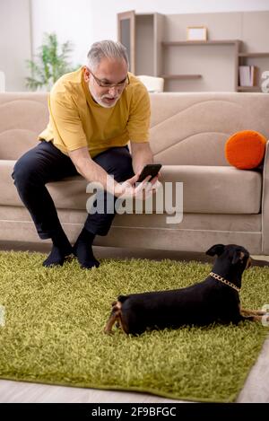 Aged man with dog at home Stock Photo