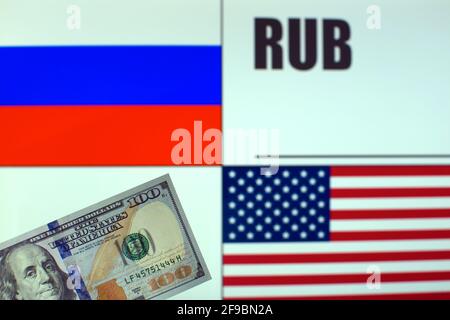 100 US dollars banknote on blurred background of Russian and American flags and Russian currency code. Template for exchange rate Stock Photo
