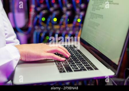 Close-up of unrecognizable female network specialist typing on laptop while updating software Stock Photo