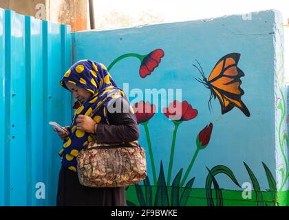 Female commuter walking past a wall painting inside Dadar Railway station in Mumbai, Maharashtra, India,Asia. Stock Photo
