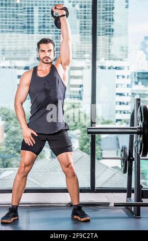 men exercising with kettle bell at gym in Bangkok Stock Photo