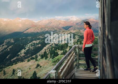 Young adventurer watching sunrise on top of fire lookout in Washington Stock Photo