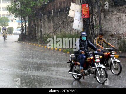 Commuters passing through road during heavy downpour in Lahore on Saturday, April 17, 2021.