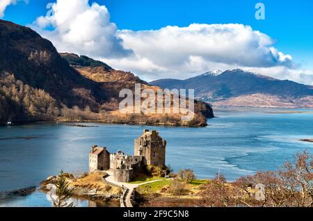 EILEAN DONAN CASTLE LOCH DUICH HIGHLANDS SCOTLAND IN SPRING SNOW CAPPED MOUNTAINS IN THE DISTANCE Stock Photo