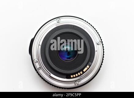 Shiny 24mm unnamed lens mount for a DSLR camera lying on a white background without a cap. Stock Photo