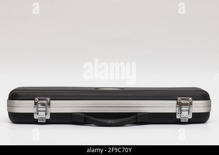 Small long black suitcase with locks for flute on a white background Stock Photo