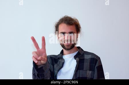 Young Hispanic man gesturing peace sign isolated on a white background Stock Photo