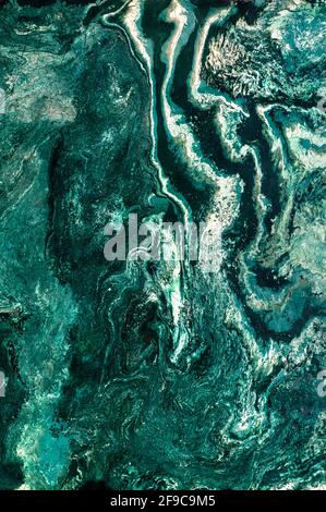 Marble texture of the polished surface with stripes, wavy streaks, malachite emerald shade. Vertical image, copy space. Stock Photo