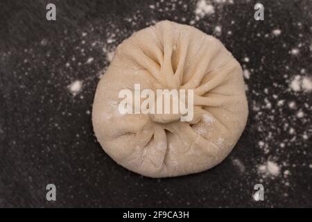Raw Georgian khinkali on a black table. Top view Stock Photo