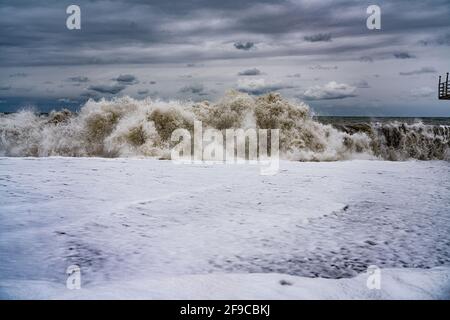 storm waves at sea against a cloudy sky Stock Photo