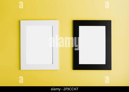 Two frames White and black photo frame on yellow background with free space. Minimalistic concept Stock Photo