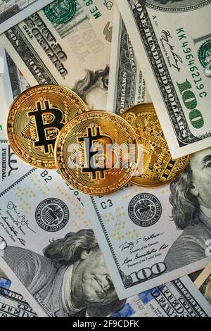 Bitcoin gold coins on US dollar bills. The concept of a peer-to-peer payment system that uses the same unit for accounting transactions. Stock Photo