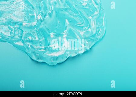 Gel with hyaluronic acid in the form of a smear of glossy texture on a cyan background. Antibacterial cosmetics Stock Photo