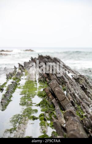 Sakoneta beach in Northern Spain full of sharp rocks  emerging from bottom the ocean Stock Photo