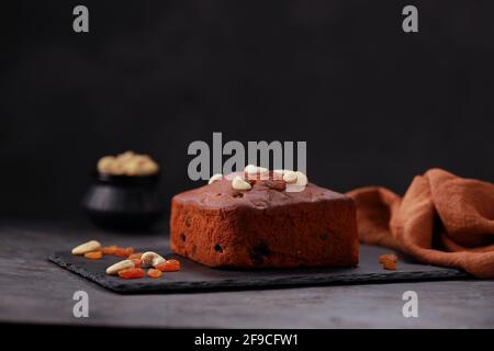 Plum cake, home made delicious christmus cake using raisins ,cashew nuts and dried fruits placed on a graphite base with grey colour background, isola Stock Photo