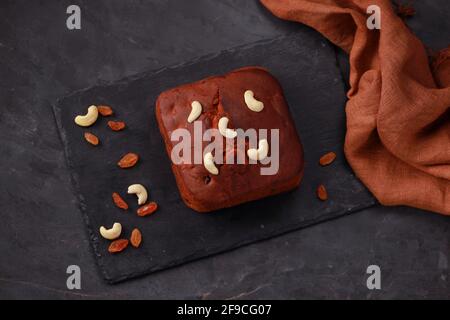 Plum cake, home made delicious christmus cake using raisins ,cashew nuts and dried fruits placed on a graphite base with grey colour background, isola Stock Photo