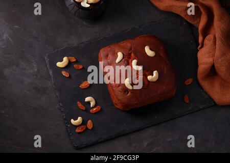 Plum cake, home made delicious christmus cake using raisins ,cashew nuts and dried fruits placed on a graphite base with grey colour background, isola Stock Photo