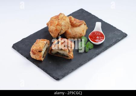 Egg Puff pastry filled with spicy and tasty egg masala and placed on graphite board with white textured background, isolated Stock Photo