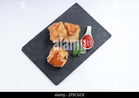 Egg Puff pastry filled with spicy and tasty egg masala and placed on graphite board with white textured background, isolated Stock Photo