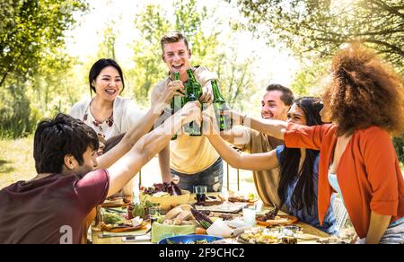 Young multiracial friends toasting at barbecue garden party - Friendship concept with happy people having fun at backyard bbq summer camp Stock Photo