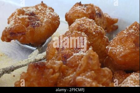 Pieces of spiced fried cod fish are collected by the fish seller Stock Photo