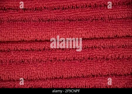 Red texture of terry towel close-up. A stack of soft bath accessories. Stock Photo