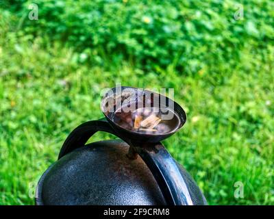 cigarette butts float in a street urn in summer Stock Photo